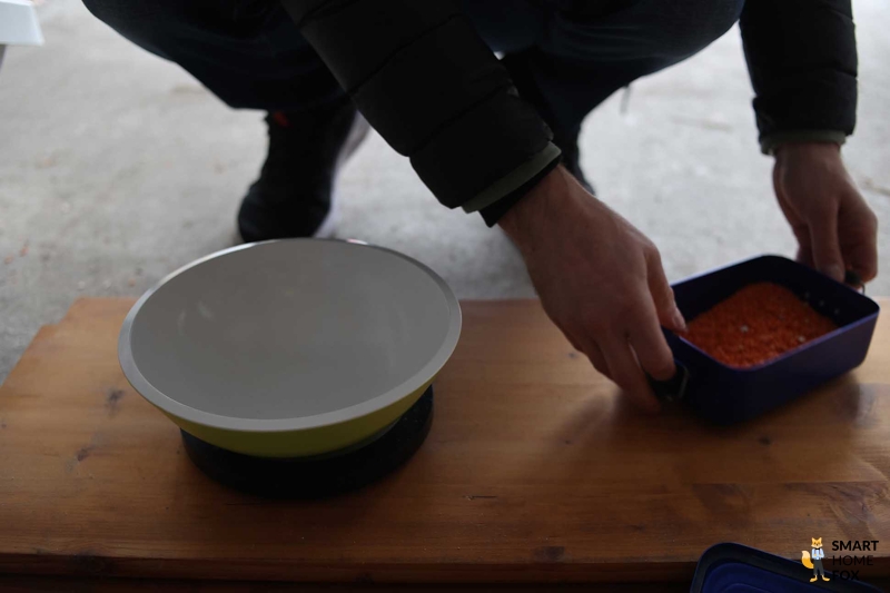 Взвешивание содержимого мобильного пылесборника Roborock S8 Pro Ultra после испытания на мощность всасывания.